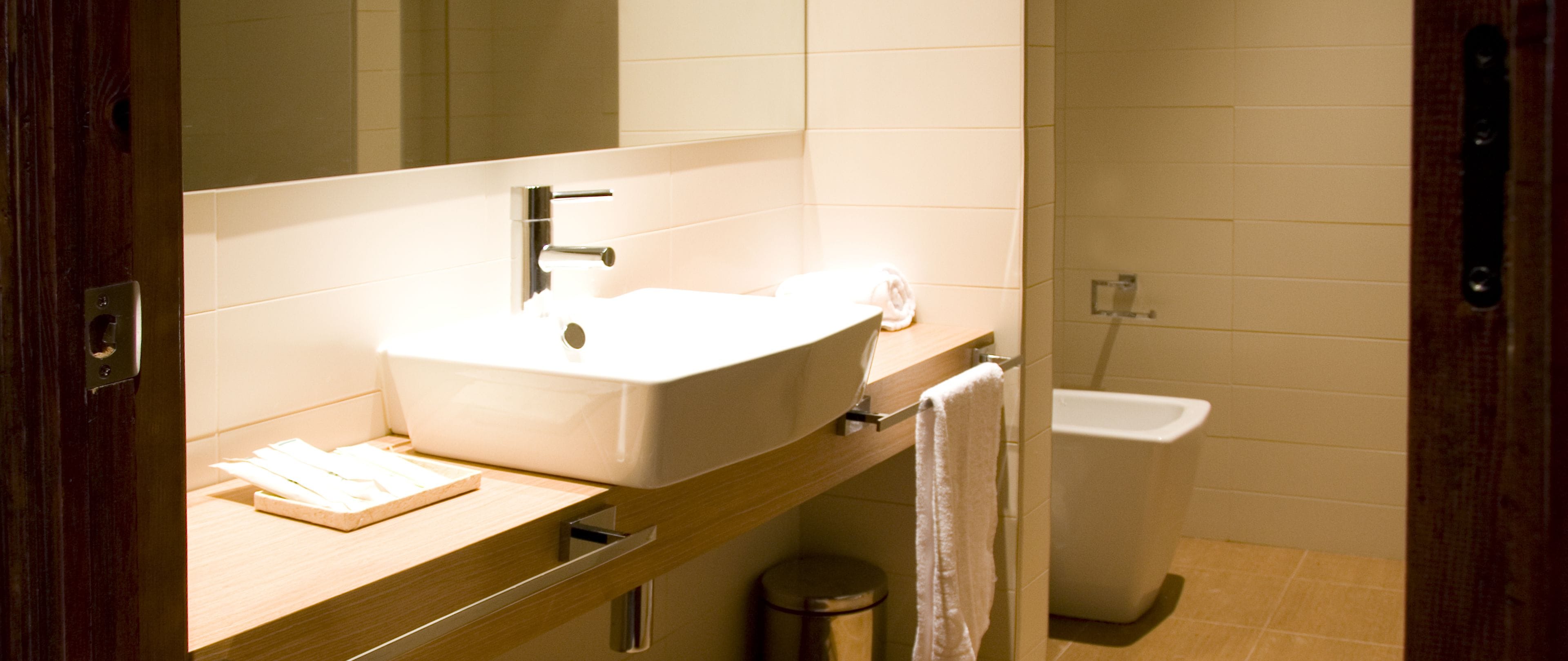 A bathroom with a sink, mirror, and toilet.