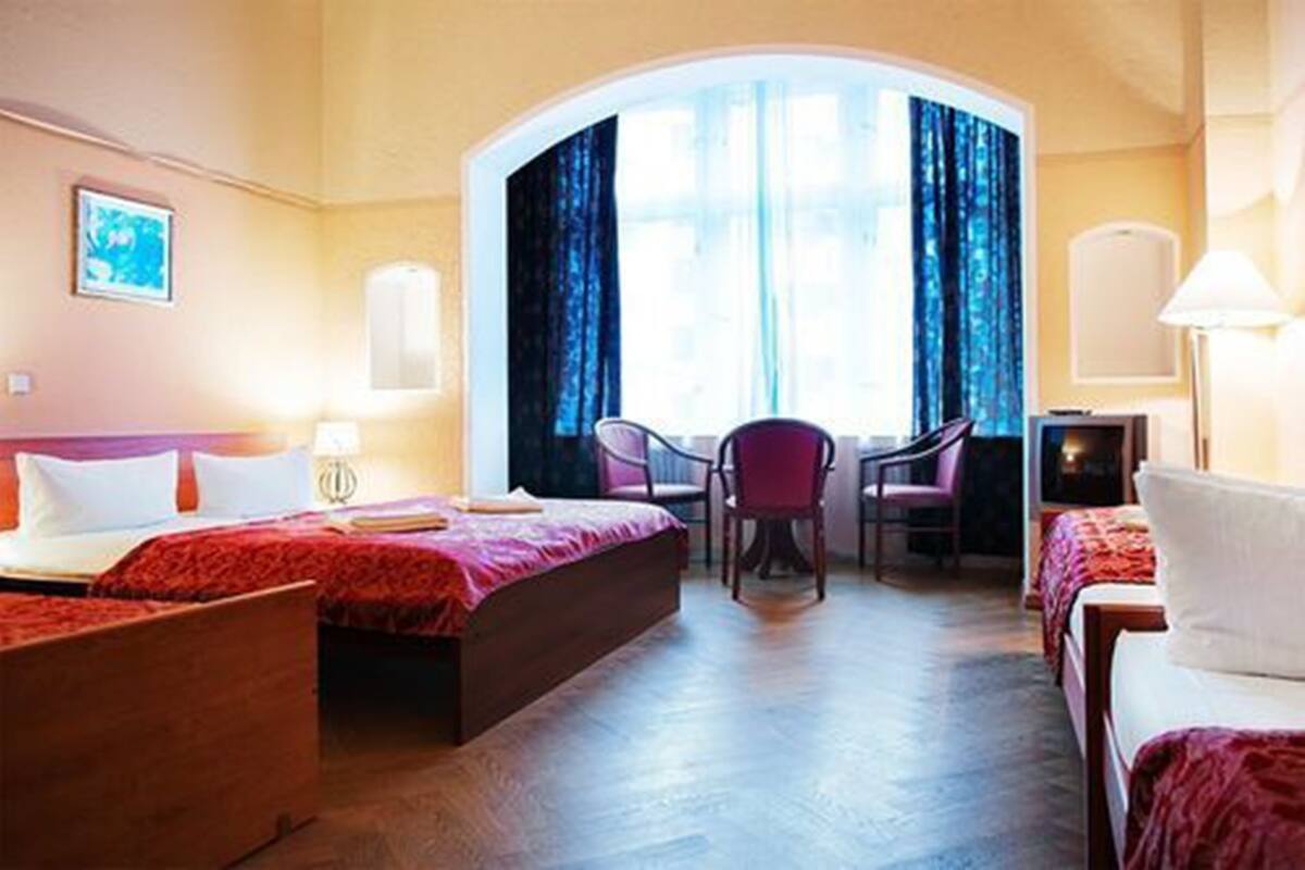 Ein Hotelzimmer mit zwei Betten, einem Schreibtisch und einem Stuhl.