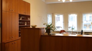 A wooden kitchen with built-in cabinets, a central island, and a potted plant. - Kurfürst am Kurfürstendamm (Berlin)