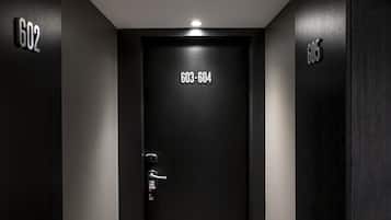 A dark wooden door with a numeric keypad and a doorbell.