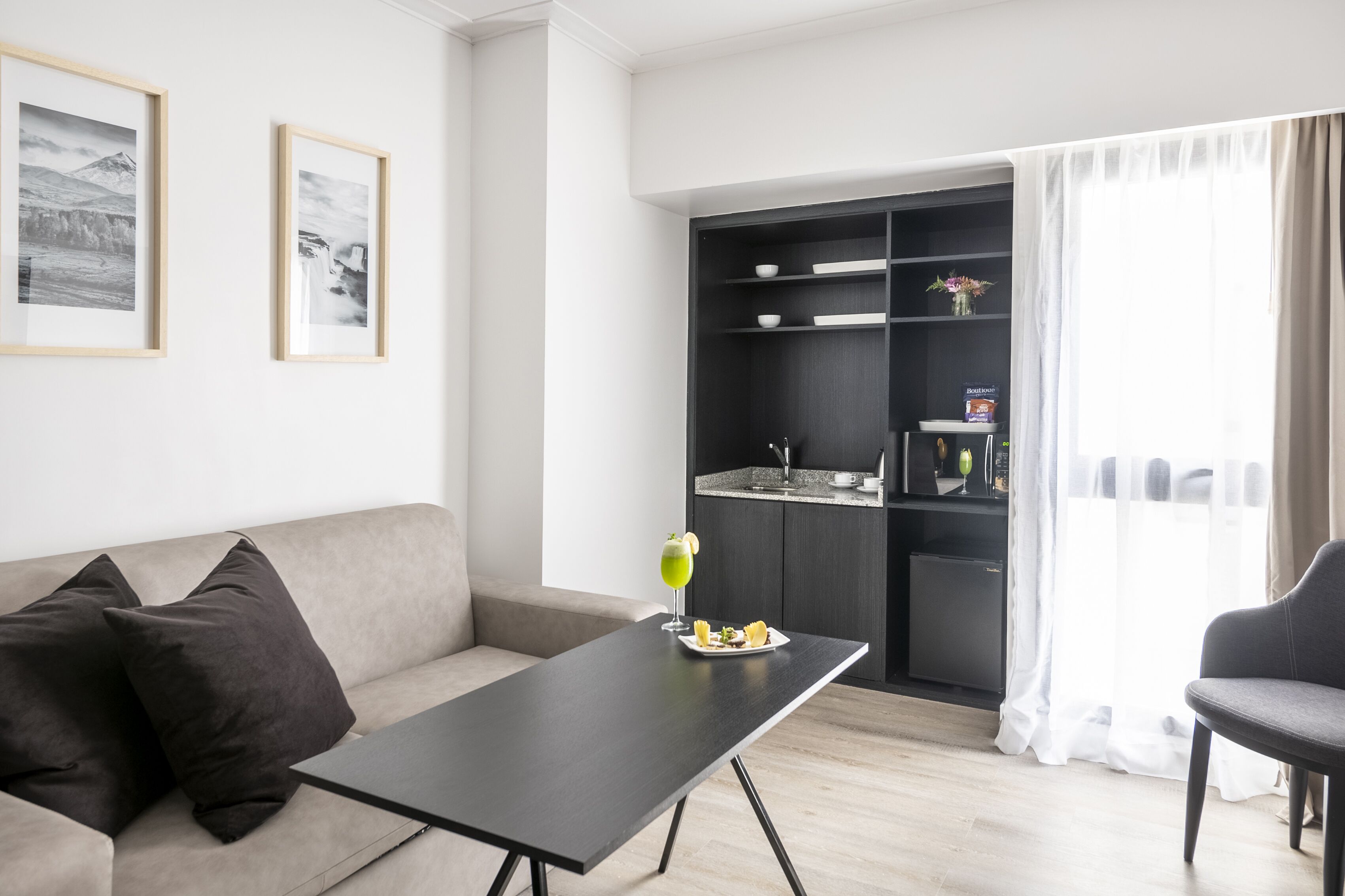 Un soggiorno moderno con un divano, un tavolino da caffè e un'area pranzo con una piccola cucina.