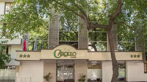 L’entrée d’un hôtel, avec une enseigne indiquant « Hôtel Carillo » et trois étoiles.