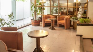 Ein modernes Interieur mit einer Sitzecke, Topfpflanzen und einer Statue.