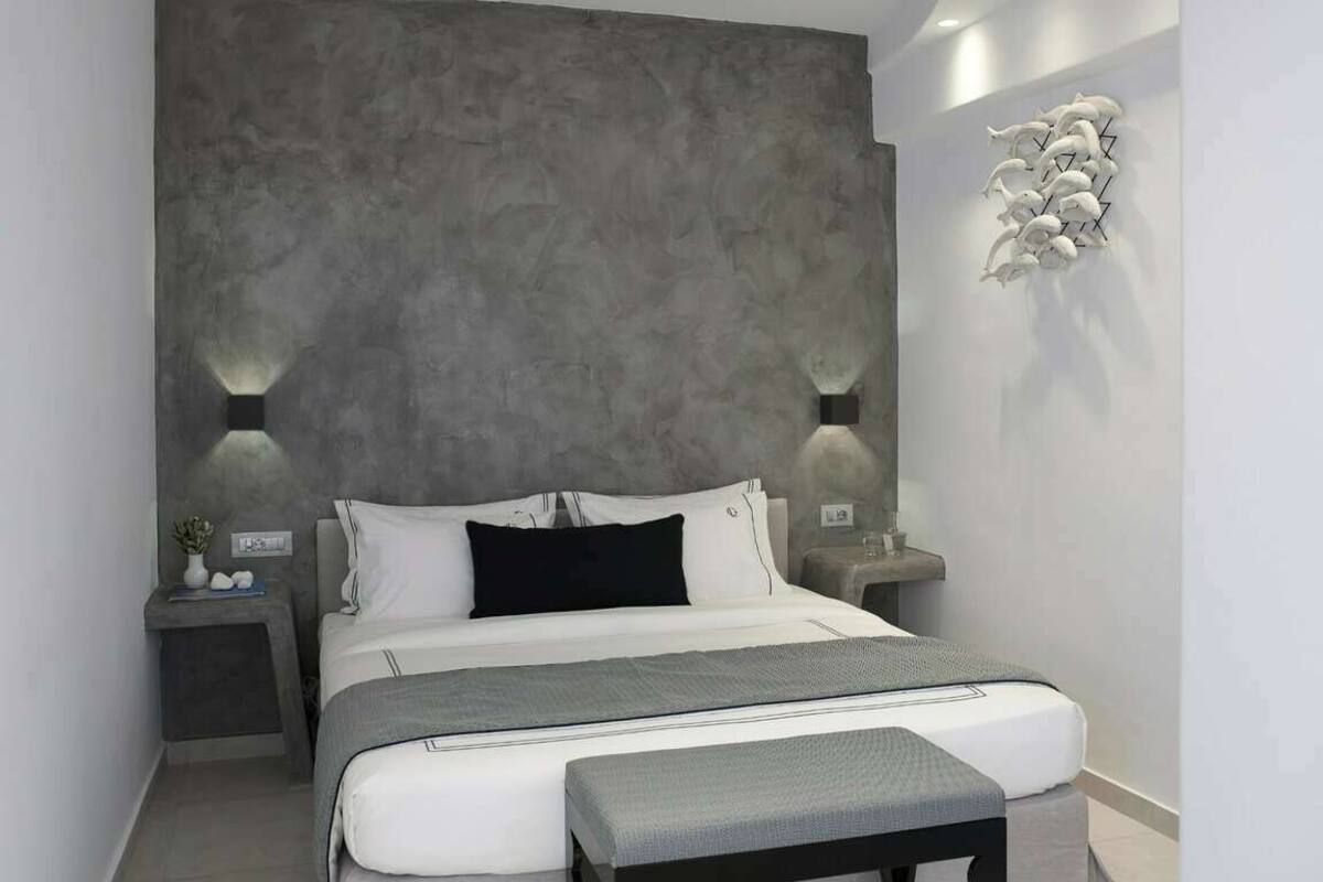 Un dormitorio moderno con una cama grande, mesitas de noche y una pieza de arte original en la pared.