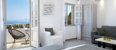 A modern bedroom with a balcony, a bed, a sofa, and a dining table.