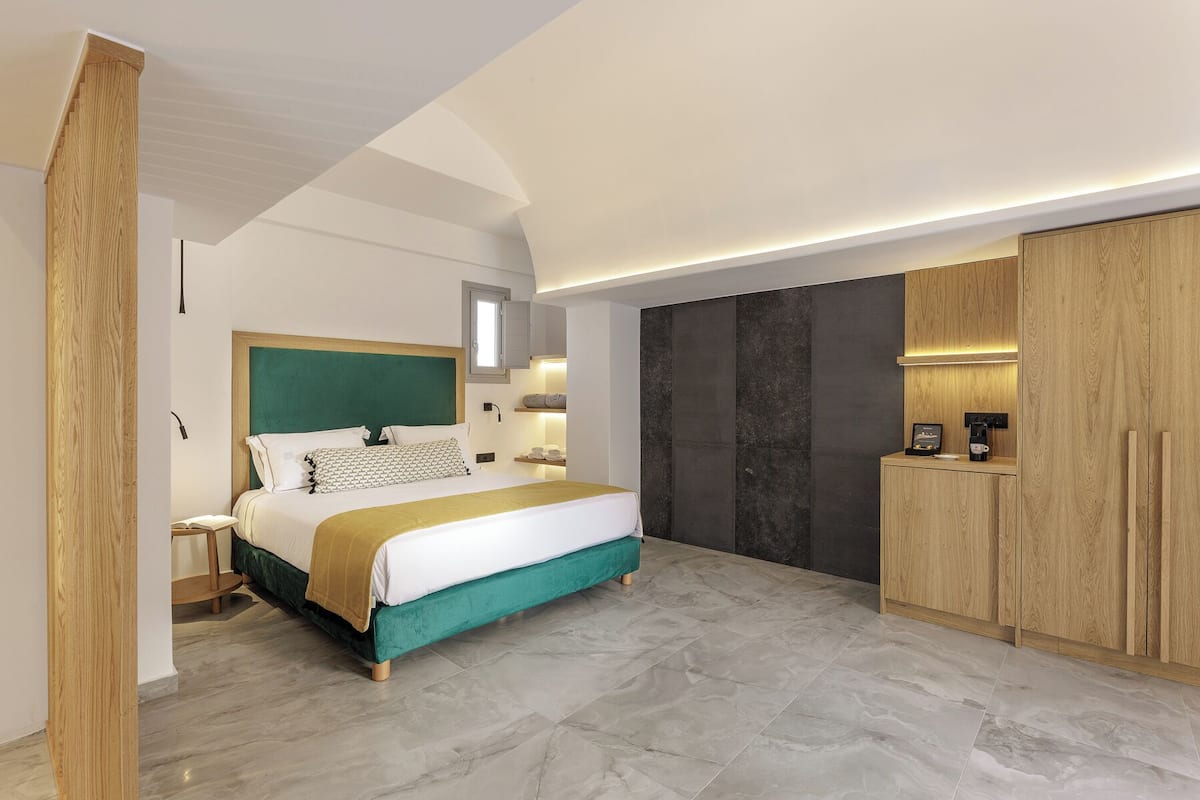 Un dormitorio moderno con una cama grande, armario de madera e iluminación empotrada.