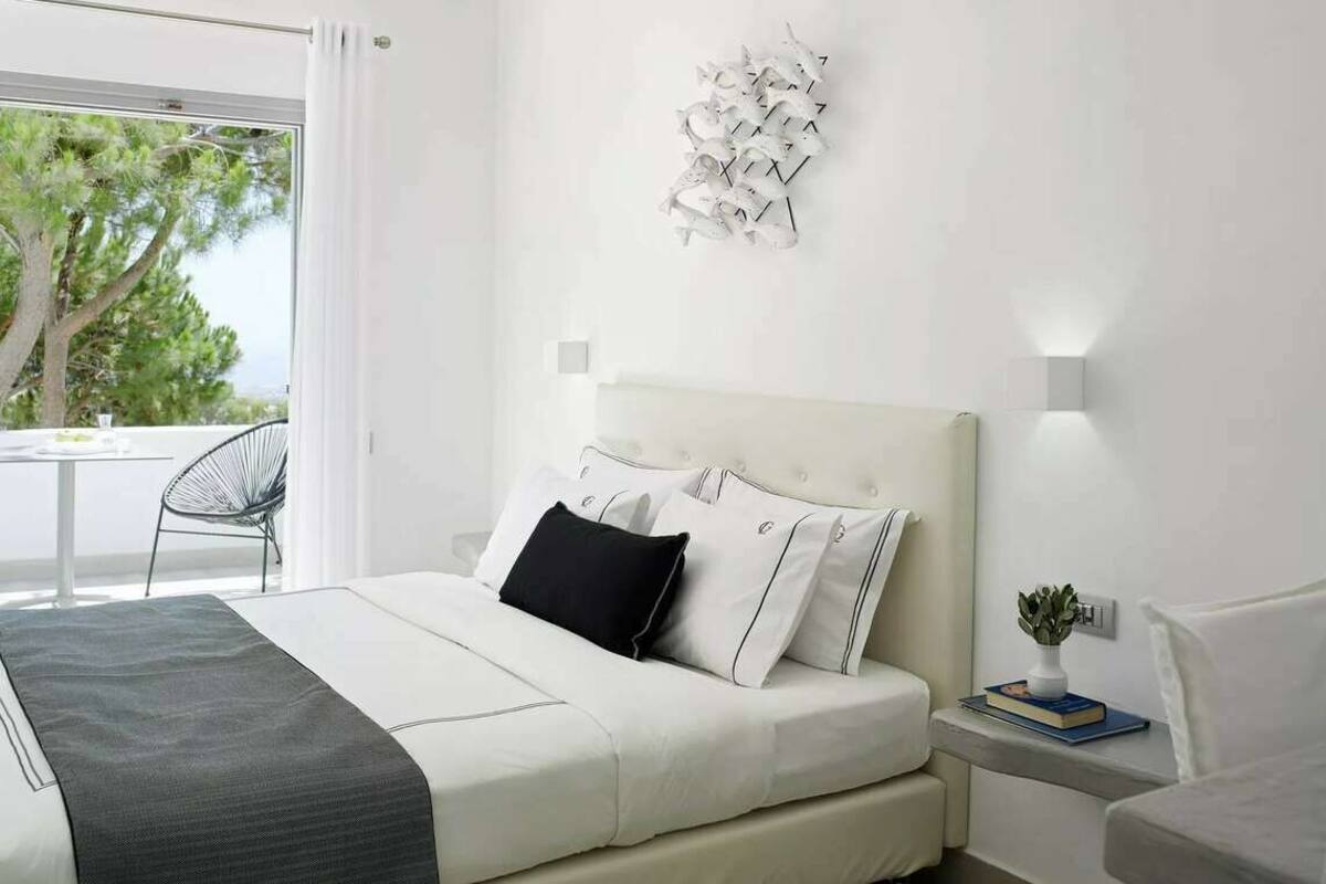 Un dormitorio moderno con cama, mesita de noche y lámpara de pared.