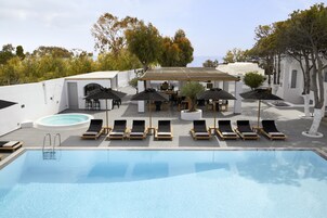 Una piscina al aire libre de temporada, sombrillas