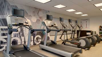 A fitness center with treadmills, ellipticals, and stationary bikes.