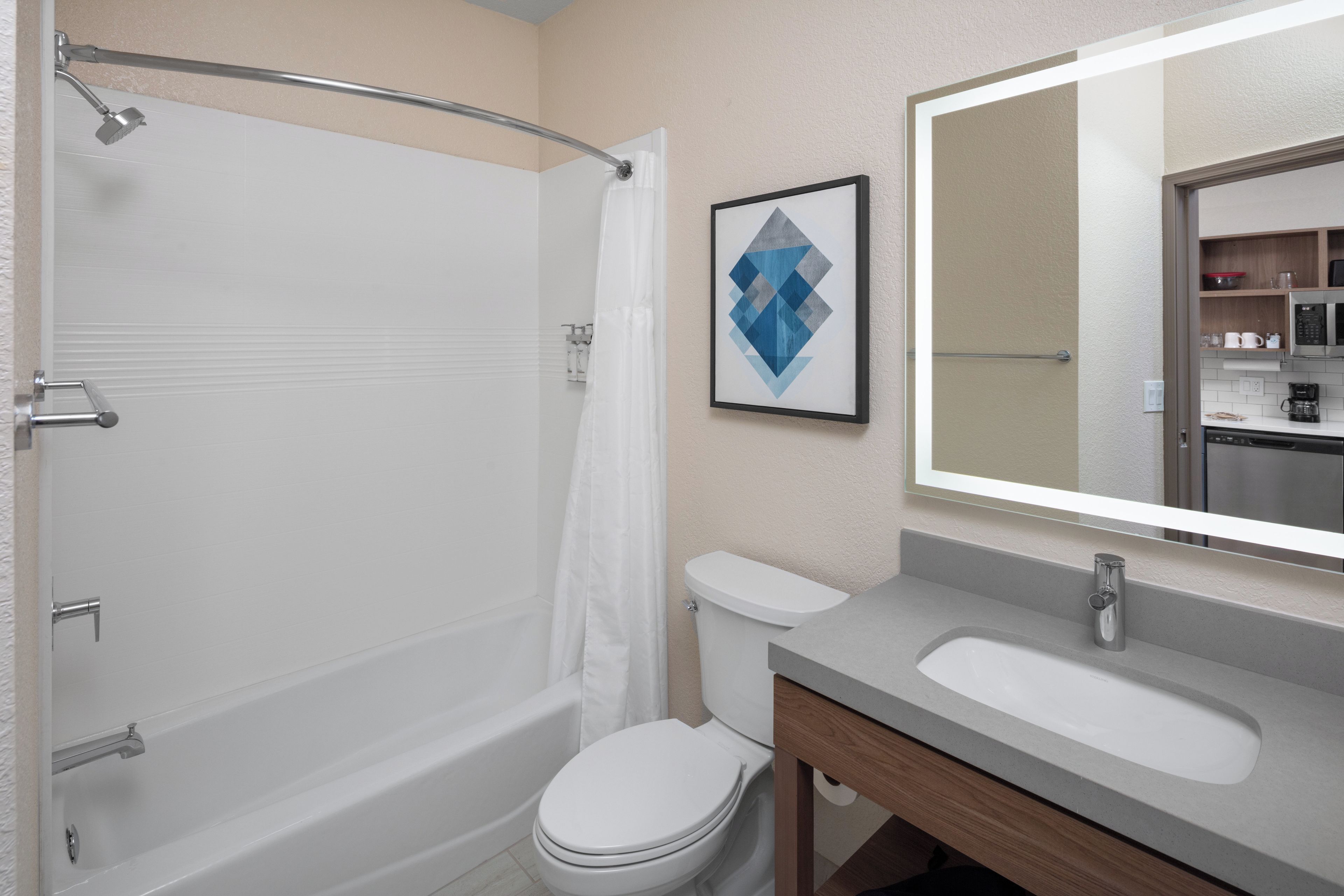 A modern bathroom with a bathtub, toilet, and sink.