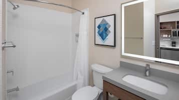 A modern bathroom with a bathtub, toilet, and sink.