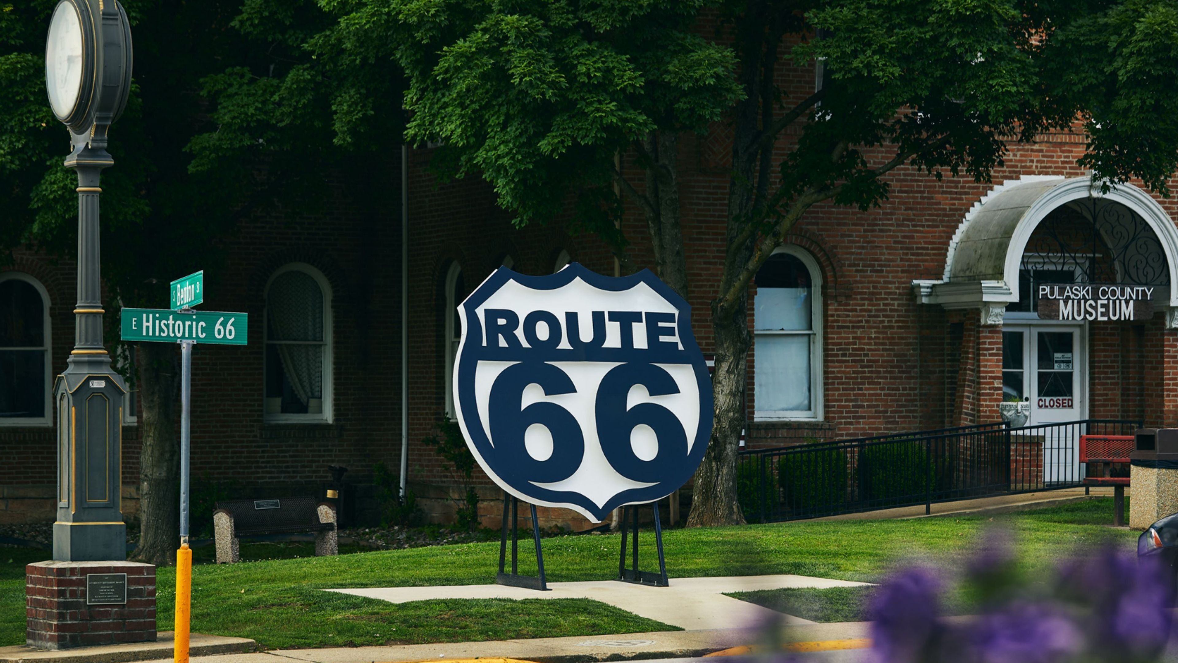 Taustalla näkyy Route 66 -tietä osoittava opaste, historiallinen muistomerkki ja Pulaski Countyn museo.