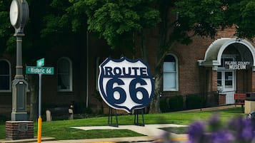 Taustalla näkyy Route 66 -tietä osoittava opaste, historiallinen muistomerkki ja Pulaski Countyn museo.