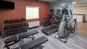 A gym with exercise equipment including dumbbells, treadmills, and a stationary bike. - Candlewood Suites St Robert by IHG (St. Robert)