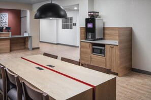 Ett modernt kök med en kaffemaskin, en mikrovågsugn och ett träskåp.