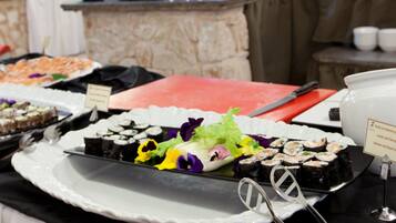 Una mesa de buffet con distintos alimentos y utensilios.