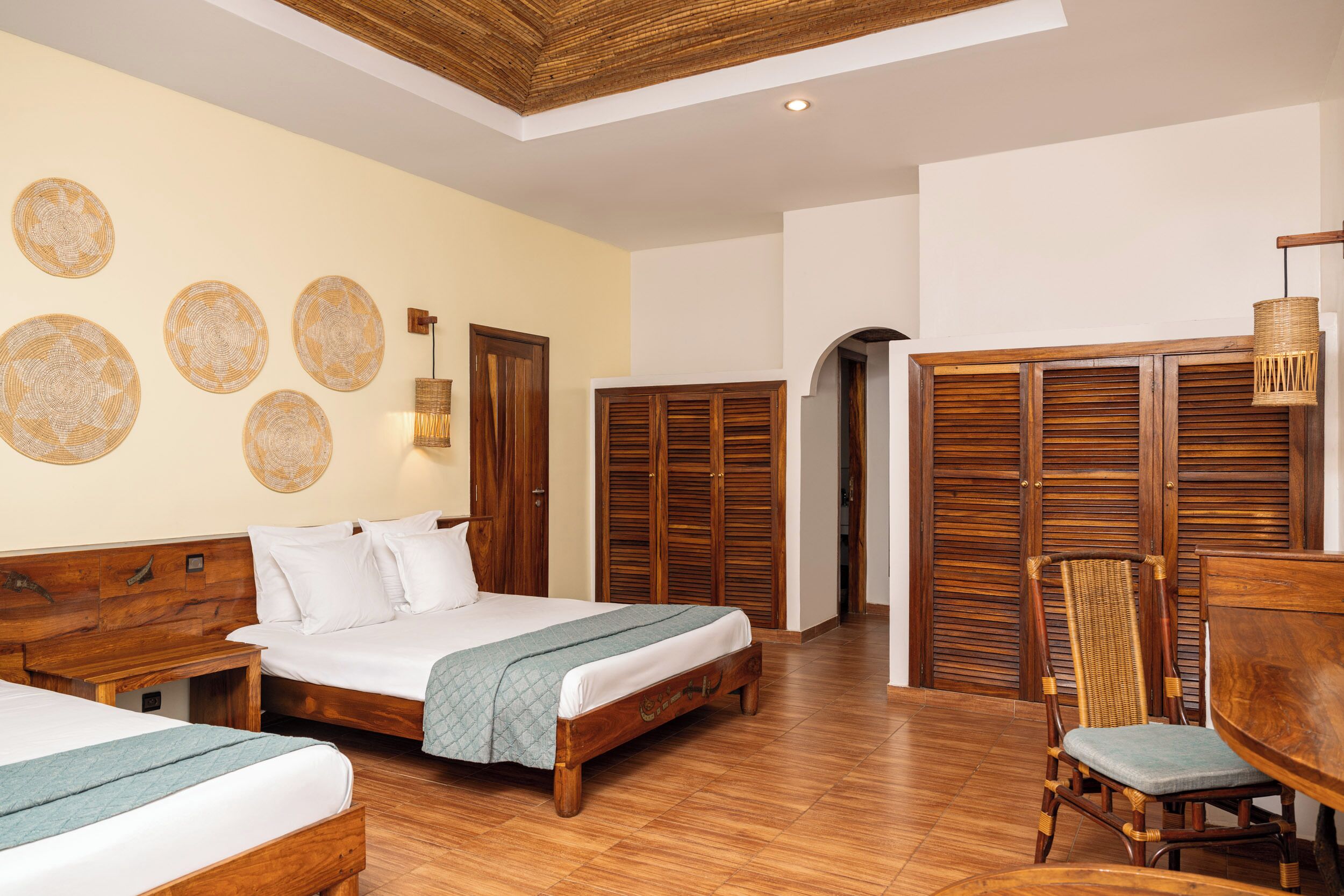 Ein Schlafzimmer mit zwei Betten, Holzmöbeln und einem Essbereich.