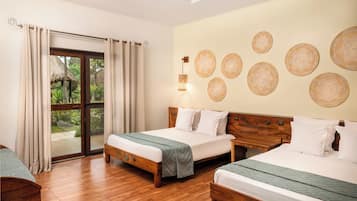 A room with two beds, a wooden floor, a large sliding glass door, and a wall with circular woven decorations.