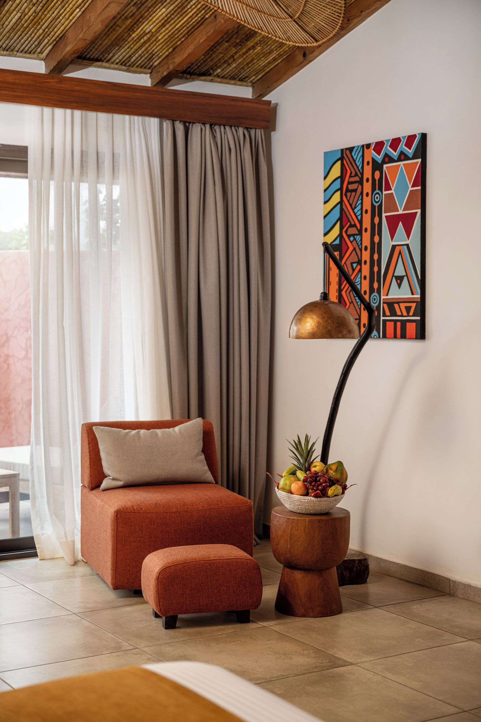 Une pièce moderne avec un canapé, une lampe sur pied et un panier de fruits.