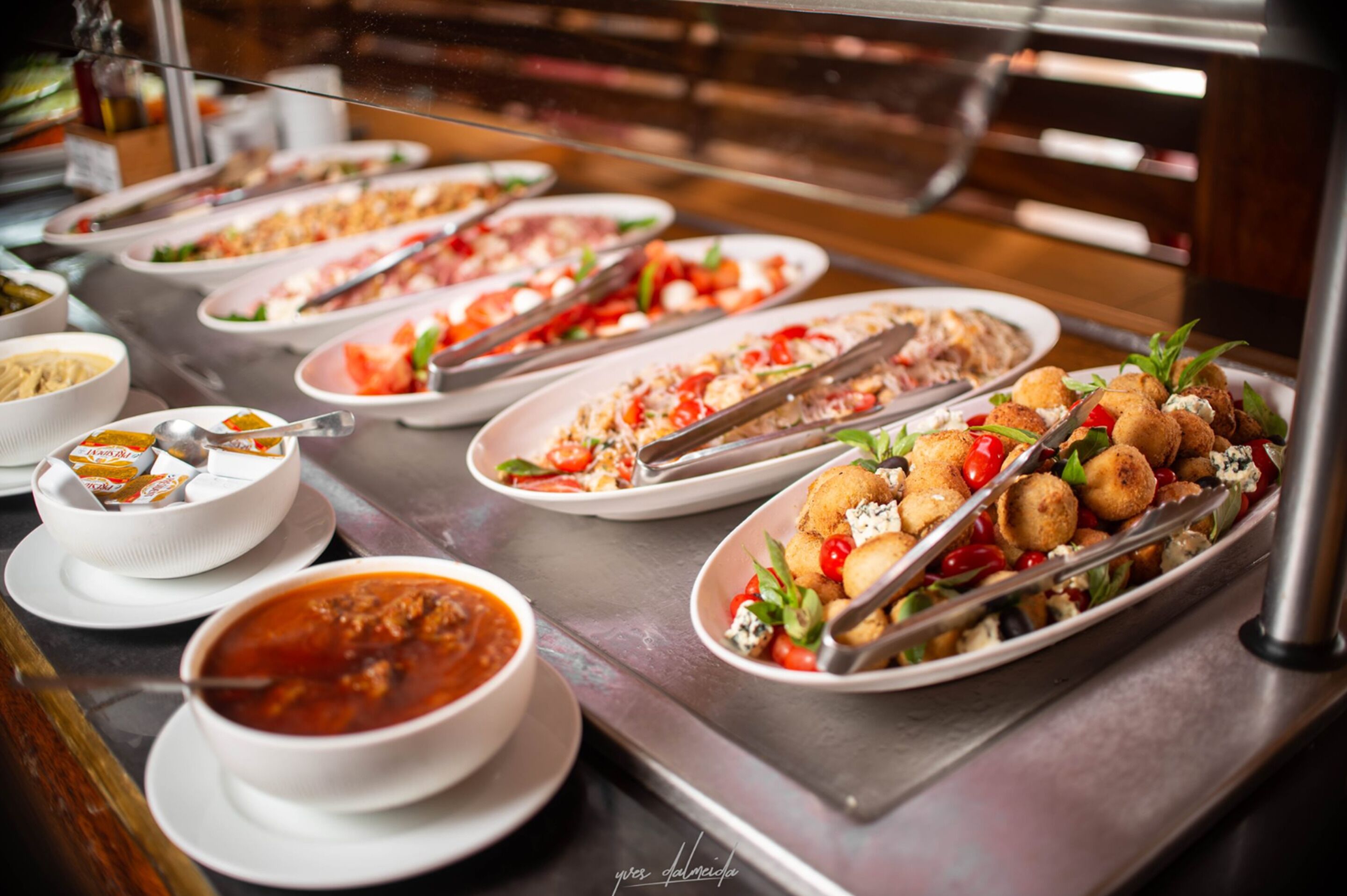 Ein reichhaltiges Buffet mit verschiedenen Gerichten, darunter Pasta, Salate und Suppe.