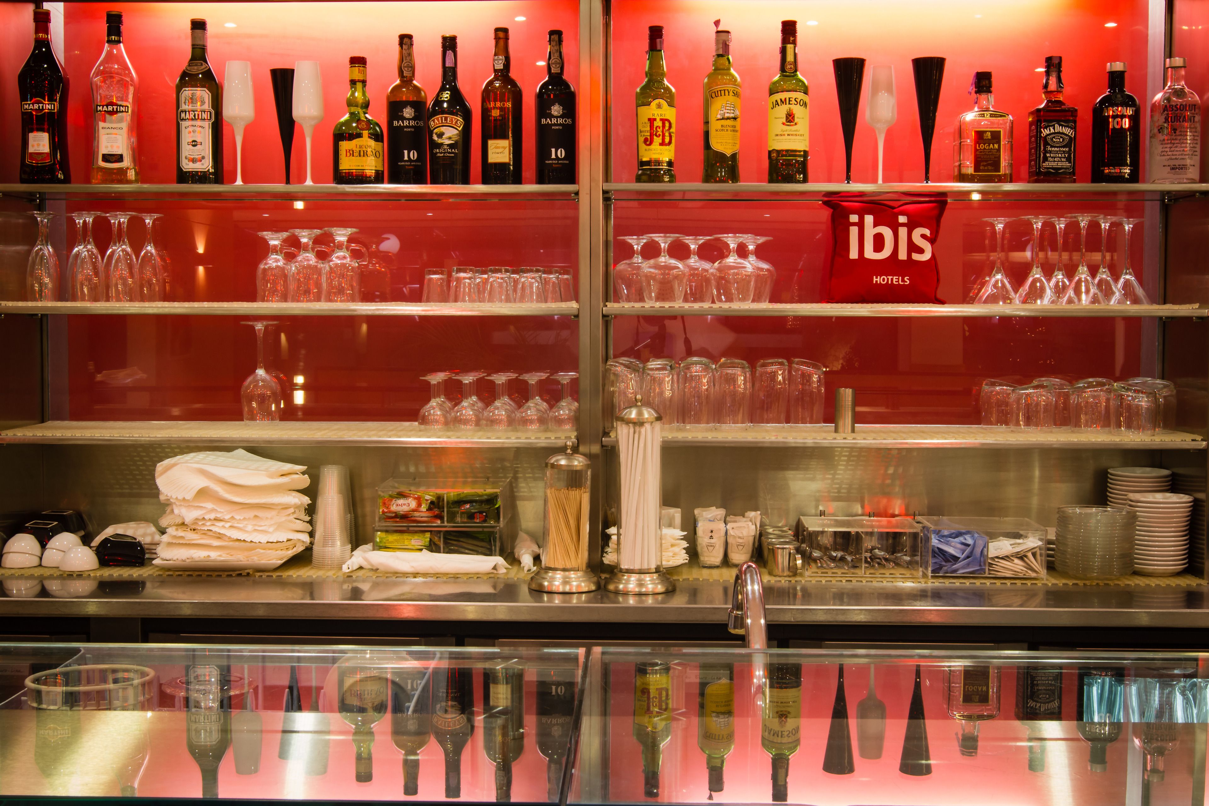 A bar area with shelves of liquor bottles and glasses.