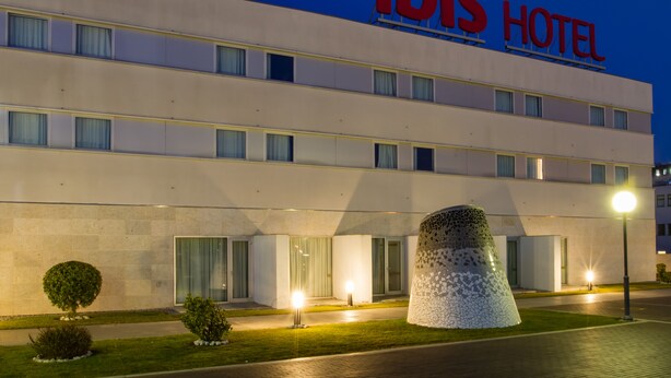 En modern hotellbyggnad med en tydlig skylt som visar texten ”ibis HOTEL”.