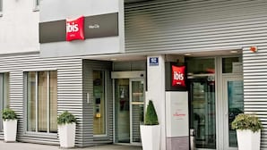A hotel with a modern facade, large windows, and a prominent 'ibis' sign. - ibis Wien City (Vienna)