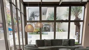 Un interior moderno con un conjunto de sofás, un sillón de cuero y una pequeña mesa.