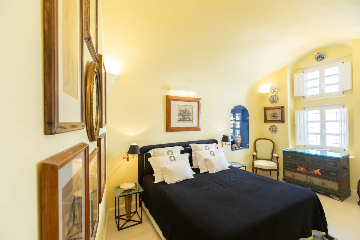 A bedroom with a bed, bedside tables, a dresser, and a chair.