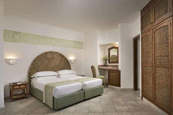 A bedroom with a large bed, bedside tables, a dresser, and a mirror.