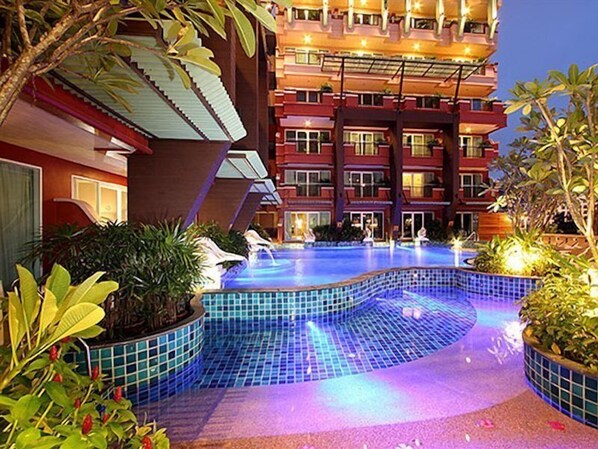 Een buitenzwembad, ligstoelen bij het zwembad