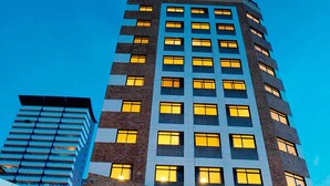 A hotel with a modern design, featuring a prominent entrance with a covered walkway and steps leading up to the main entrance. - Maredomus Hotel (Fortaleza)