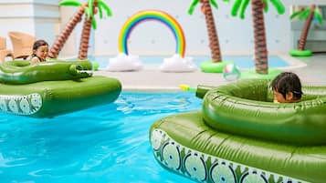 Relax by the pool surrounded by tropical palm trees and vibrant decor.