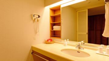 Un baño de hotel con lavamanos, espejo y teléfono.
