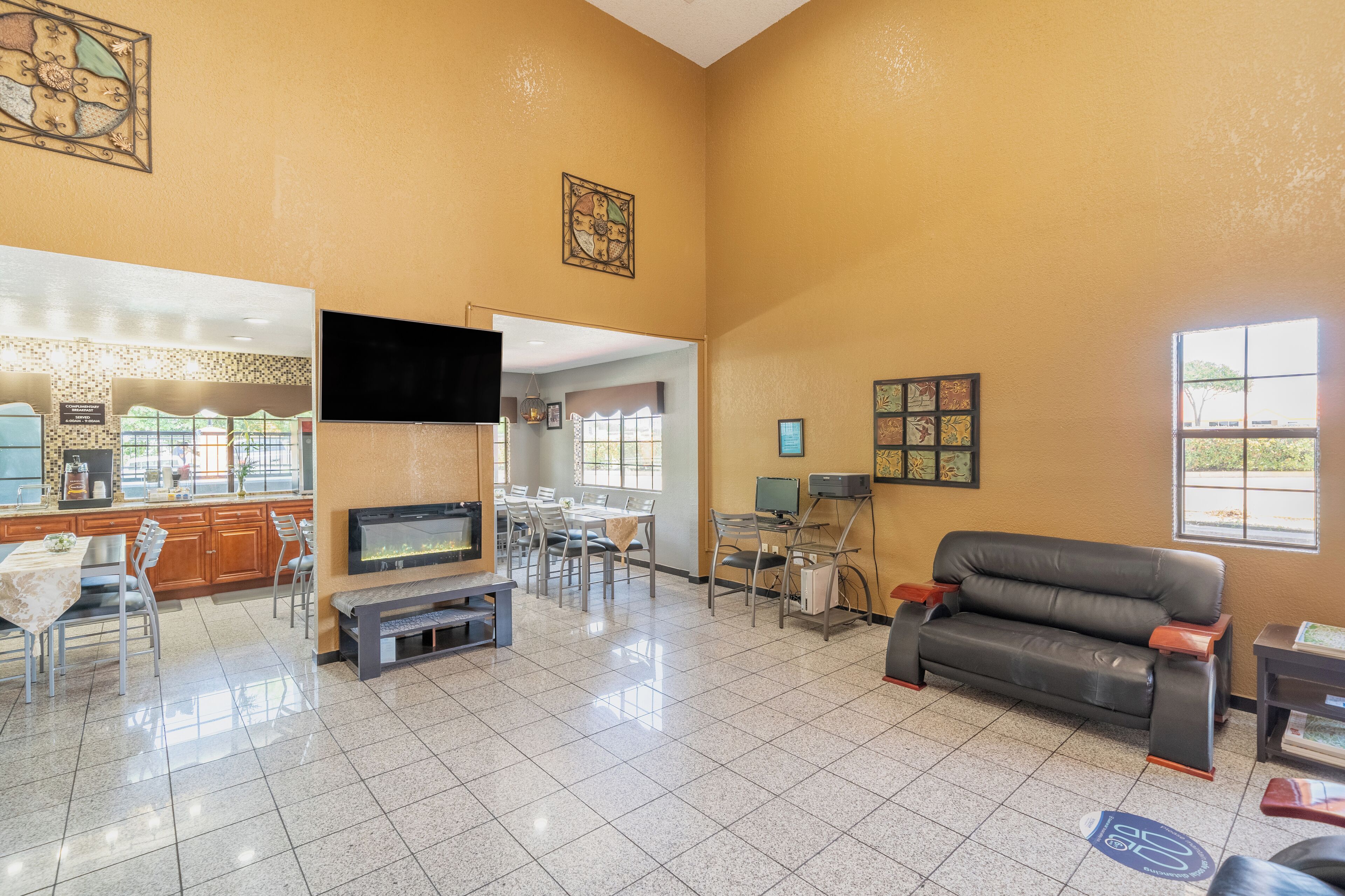 A spacious living area with a sofa, TV, and dining setup.