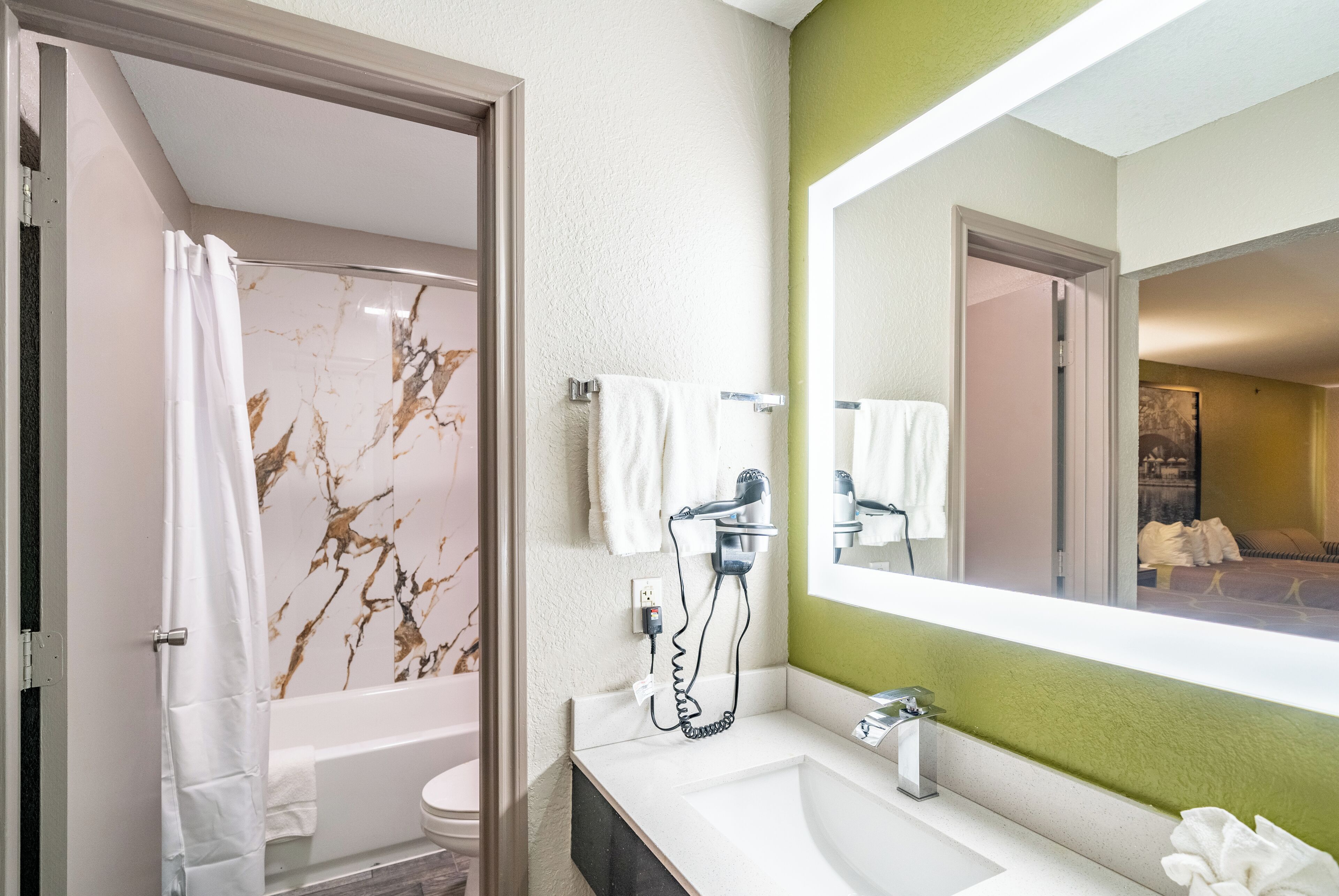 A bathroom with a bathtub, a sink, a mirror, and a shower curtain.