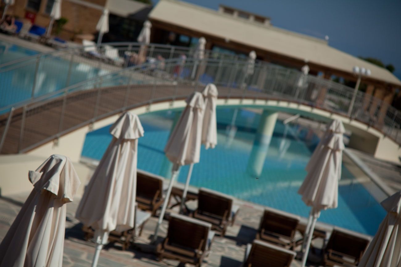 A pool area with lounge chairs and umbrellas.