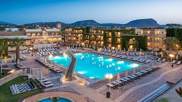 Relax by the inviting pool surrounded by sun loungers and umbrellas, with breathtaking views of the surrounding hills and distant mountain.