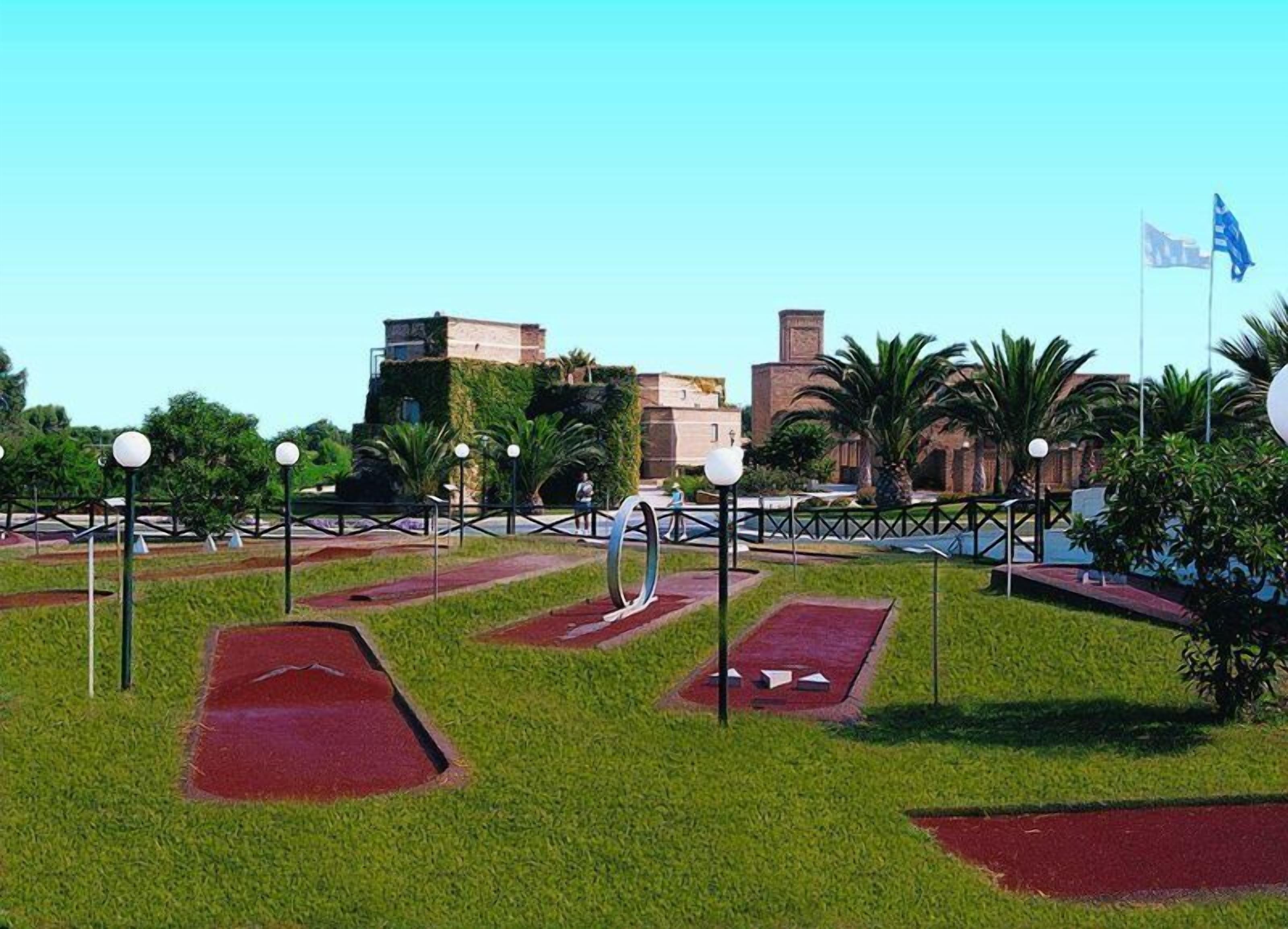 A landscaped area with a pathway, a fountain, and a flag.