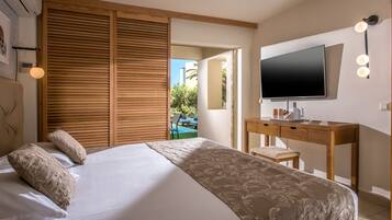 Ein Schlafzimmer mit Bett, Schreibtisch, Fernseher und Blick ins Freie.