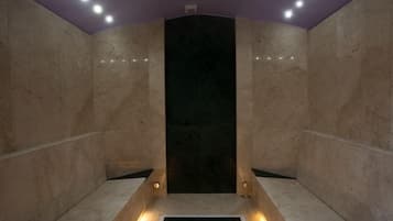 Bathroom features a central sink, marble walls, and recessed lighting.