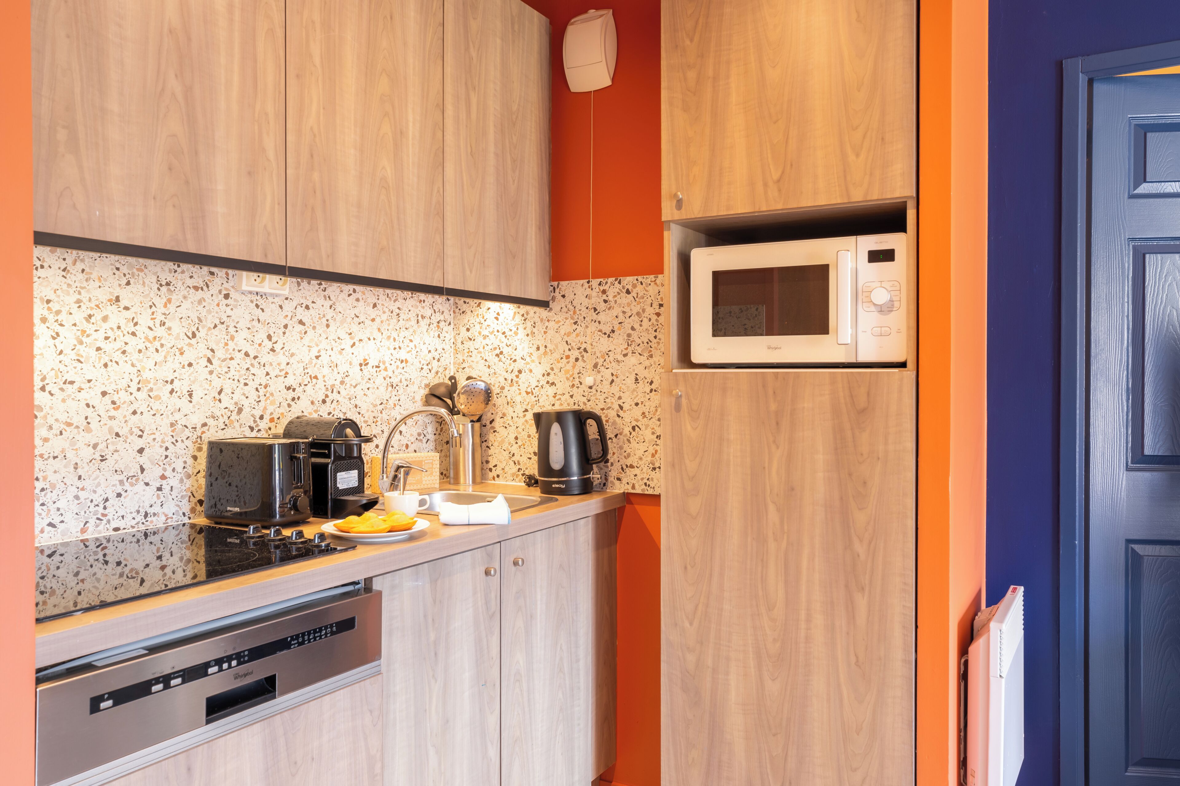A kitchen with wooden cabinets, a microwave, a coffee maker, and a dishwasher.