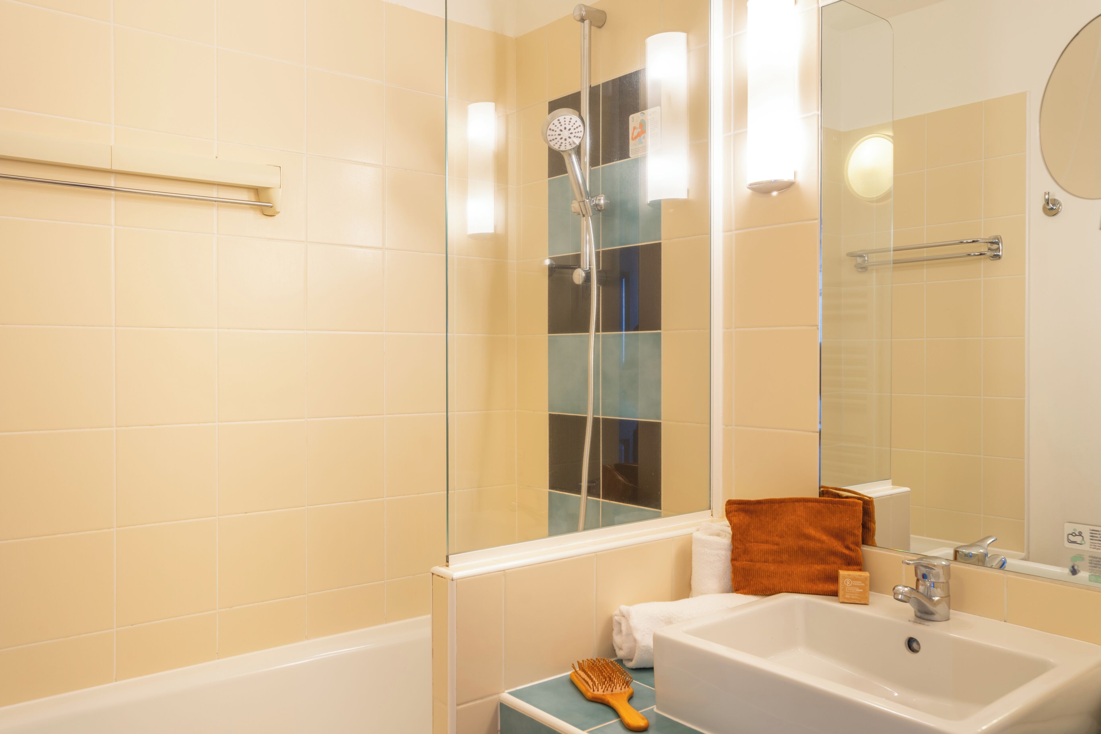 A bathroom with a bathtub, a shower, a sink, a mirror, and a towel rack.