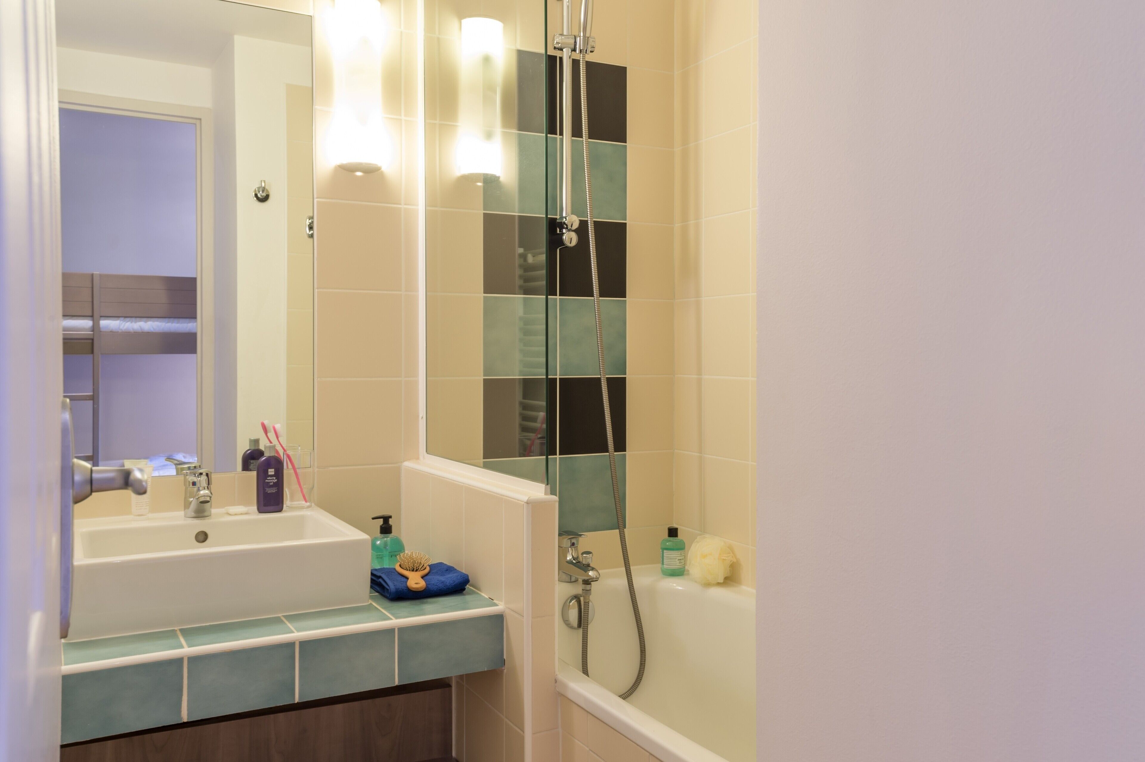 A bathroom with a sink, mirror, shower, and bathtub.