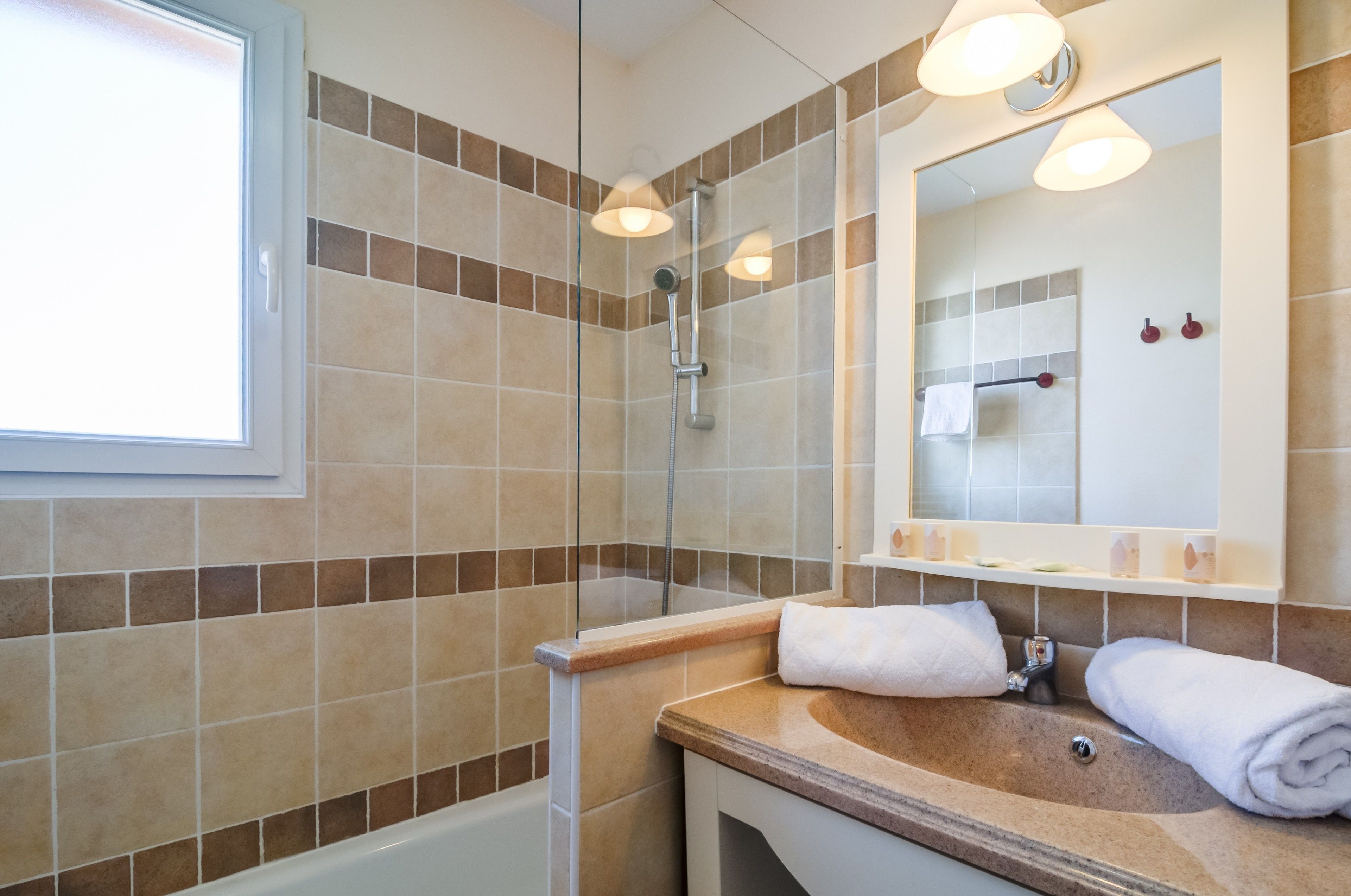 Une salle de bain avec une douche, un lavabo et un miroir.