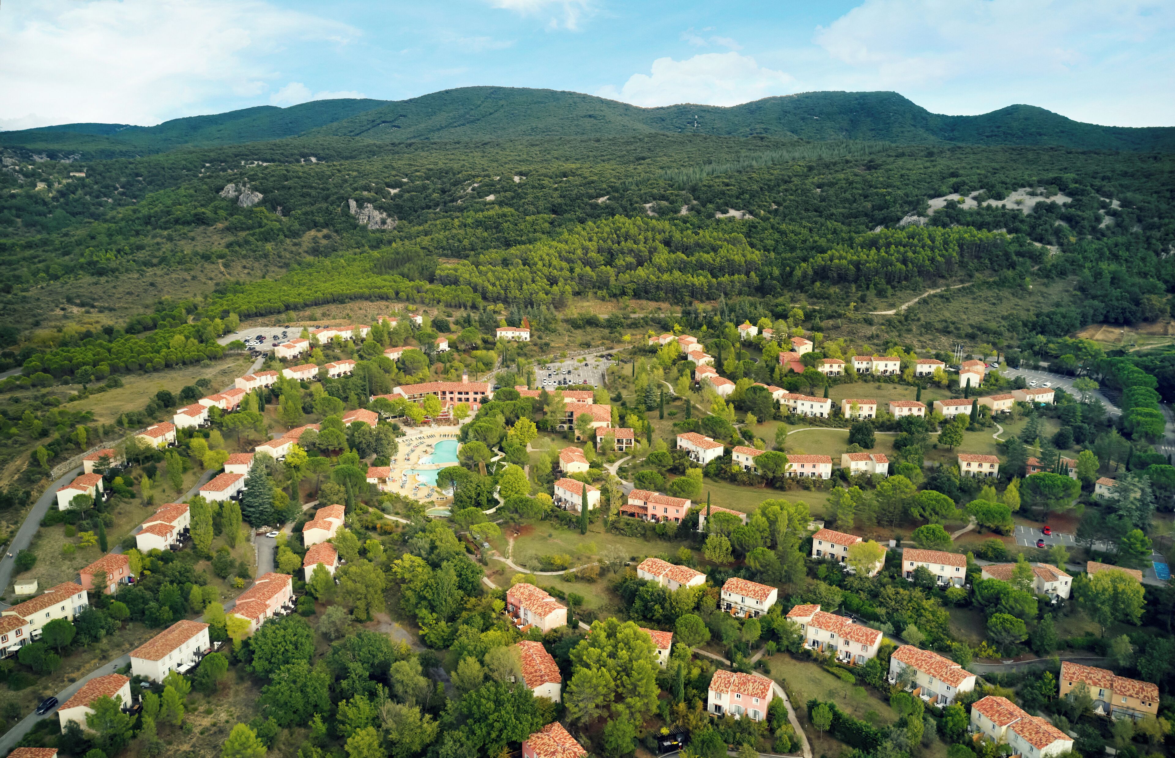 A residential area with houses arranged in a semi-circular pattern around a central swimming pool.
