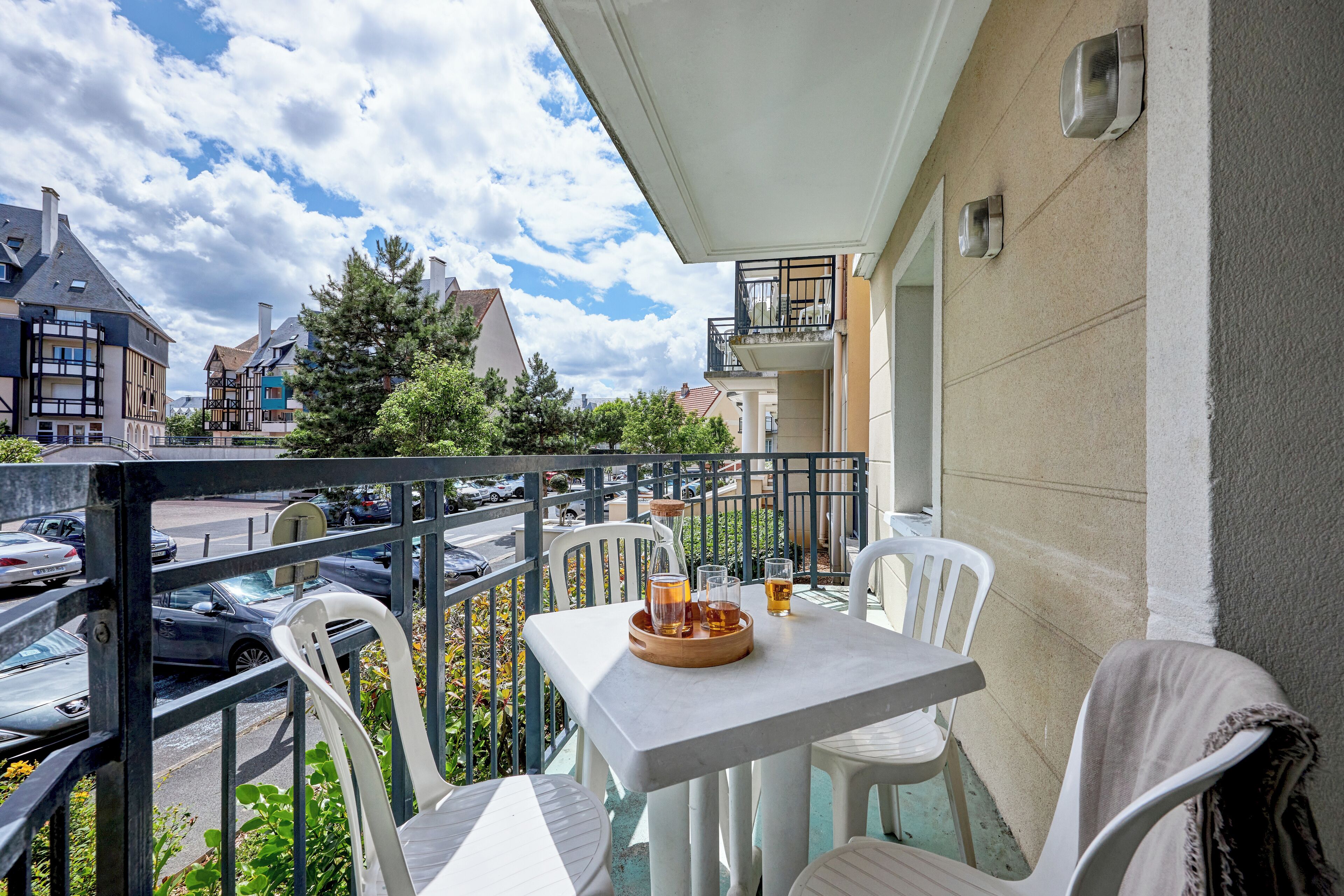 Ein Balkon mit Tisch, Stühlen und einer Bierflasche.
