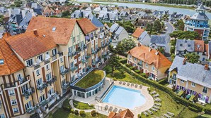 A residential area with a swimming pool surrounded by apartment buildings. - Pierre & Vacances Résidence Port Guillaume (Dives-sur-Mer)