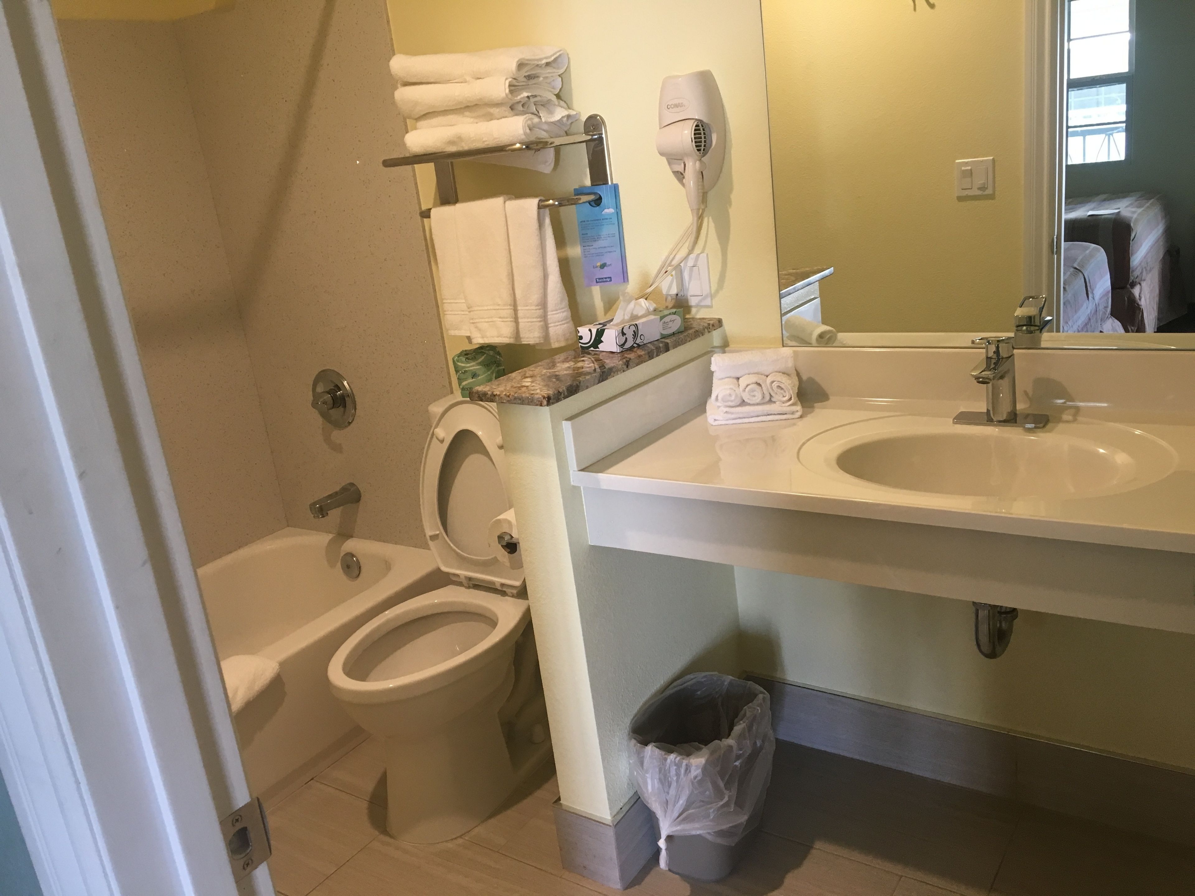 Un baño con inodoro, lavamanos y toallero.