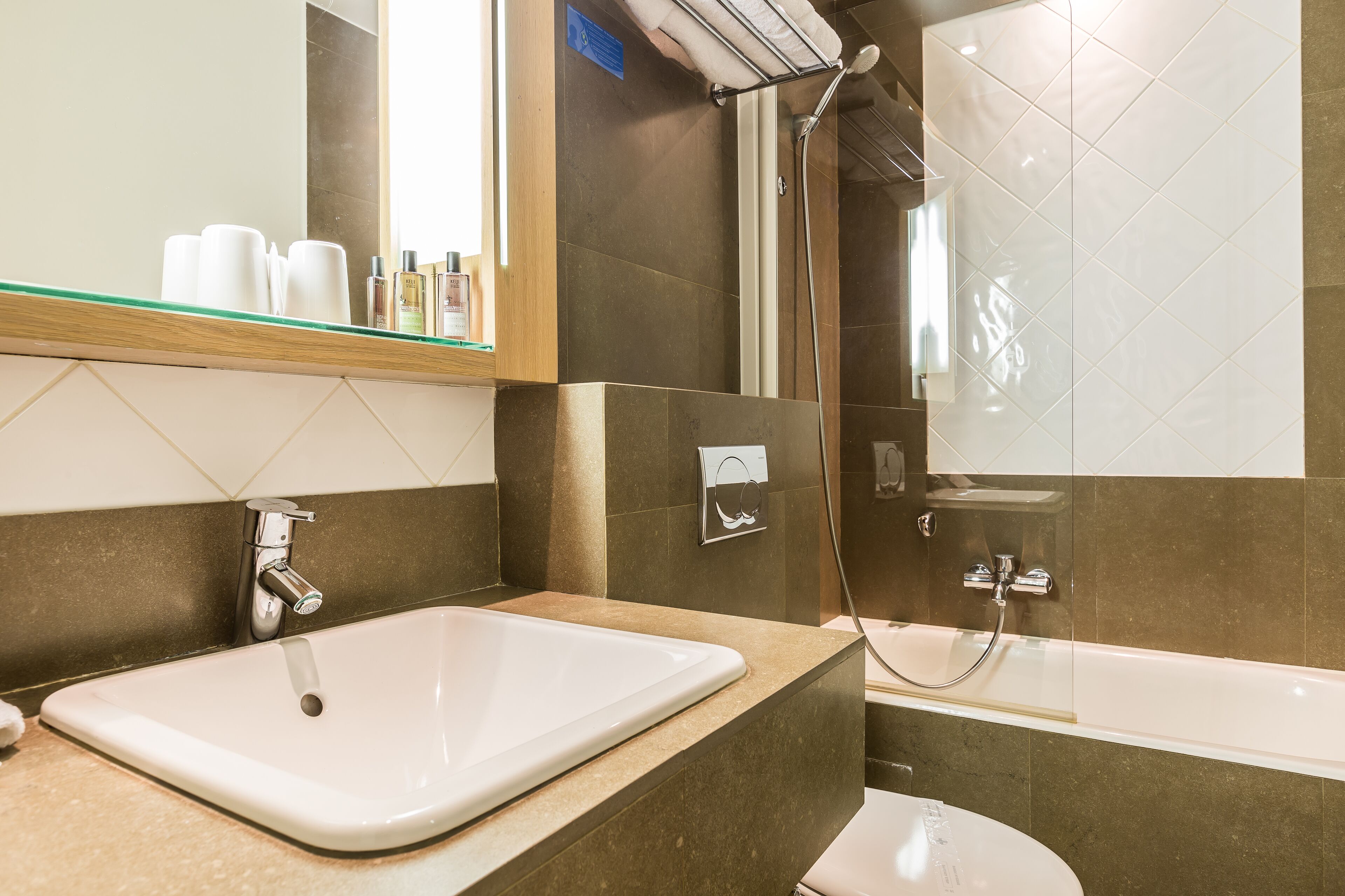 Ein modernes Badezimmer mit Waschbecken, Spiegel und Dusche.